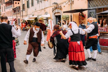 Nemi, Italy -June 6, 2021, strawberry festival takes place in the town of Nemi in the Castelli Romani, just south of Rome. Festive celebration and songs. Nemi residents typical dresses attending  clipart