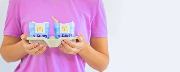 Mulher de t-short roxo segurando um sorvete Mcflurry. Entrega McCafe. restaurante de fast food Mcdonalds. Leve o sorvete Mcflurry — Fotografia de Stock