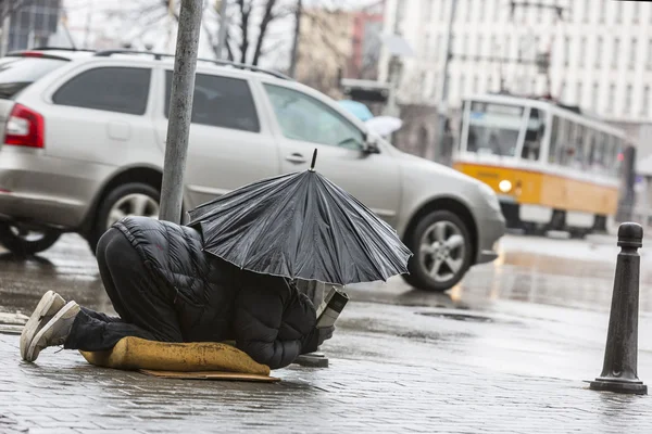 Mendigo sem-teto com guarda-chuva na chuva — Fotografia de Stock
