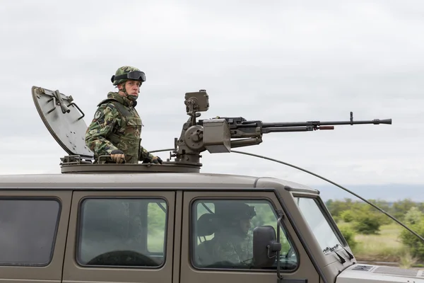 Veículo militar com metralhadora pesada e soldado — Fotografia de Stock