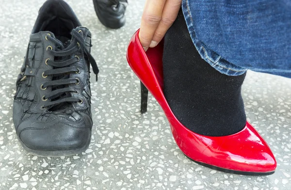 Hombre poniéndose zapatos rojos para damas — Foto de Stock
