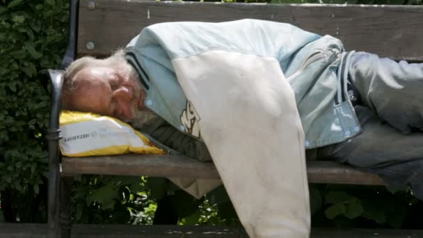 Obdachloser schläft auf einer Bank. Auszoomen. — Stockvideo