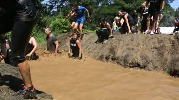 Extreme sport uitdaging springen in modderig water — Stockvideo