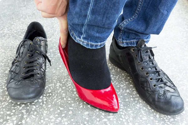 Hombre poniéndose zapatos rojos para damas — Foto de Stock