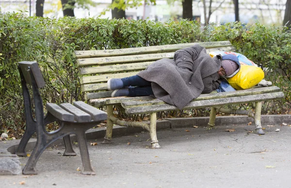 Homeless man sleeping on a bench — Stock Photo, Image