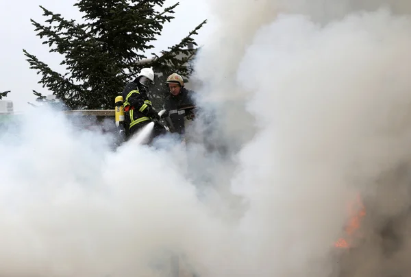 Firefighters burning house — Stock Photo, Image