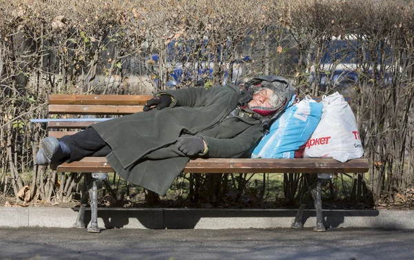 Hajléktalan nő egy padon alszik — Stock Fotó