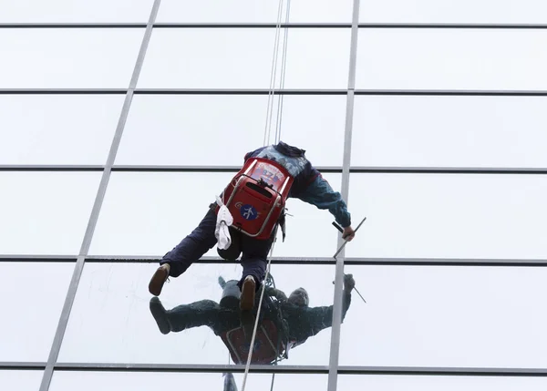 Trabajador de saneamiento limpieza fachada de vidrio hotel —  Fotos de Stock