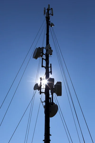 Communication tower silhouette against blue sky — Φωτογραφία Αρχείου