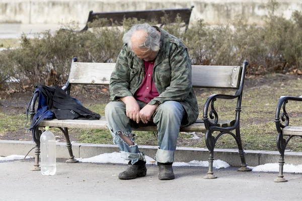 ベンチで寝ているホームレスの男性 — ストック写真