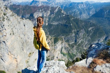 Genç bir kız dağın tepesinde duruyor ve vadiye bakıyor, nefes kesici bir manzara, Grlo Sokolovo, Karadağ ile Arnavutluk 'u ayıran vadi.
