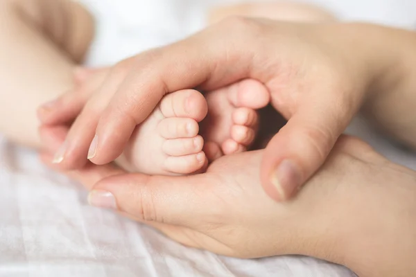 Pés de bebê em mãos de mãe — Fotografia de Stock