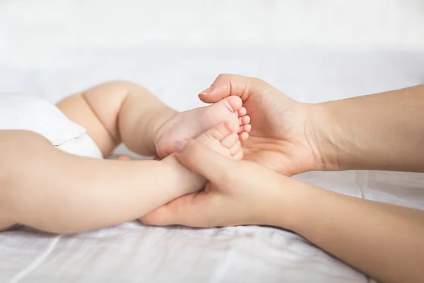 Дитячі ноги в руках матері — стокове фото