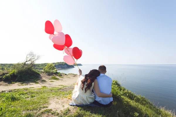 Happy wedding couple with red balloons — Stock Photo, Image