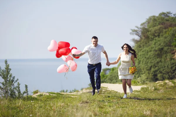 Pareja feliz boda con globos rojos — Foto de Stock