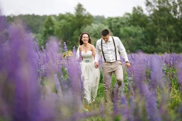 Happy wedding couple in lupin — Stock Photo, Image