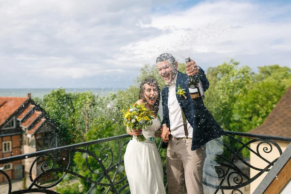 Cheerful couple open champagne — Stock Photo, Image