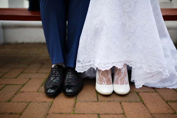 Жених и невеста в яркой одежде на скамейке — стоковое фото