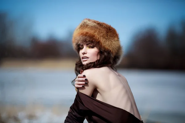 Ritratto di una bella ragazza sorridente con un cappello di pelliccia — Foto Stock