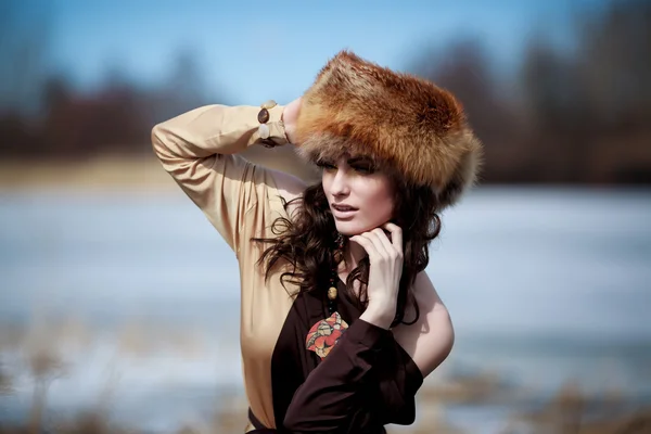 Portrait of a beautiful smiling girl in a fur hat — Stock Photo, Image