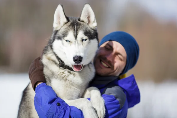Ευτυχισμένος άνθρωπος με έναs σκύλος χάσκεϋ — Φωτογραφία Αρχείου