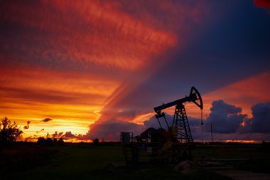 Oil derricks on a background of beautiful sunset clipart