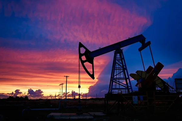 Güzel gün batımı bir arka plan üzerinde petrol derricks