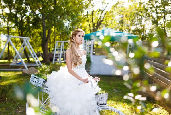 Pretty young bride with bike — Stock Photo, Image