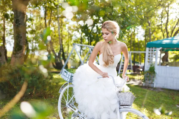 Pretty young bride with bike