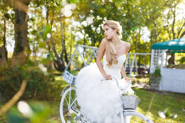 Pretty young bride with bike — Stock Photo, Image