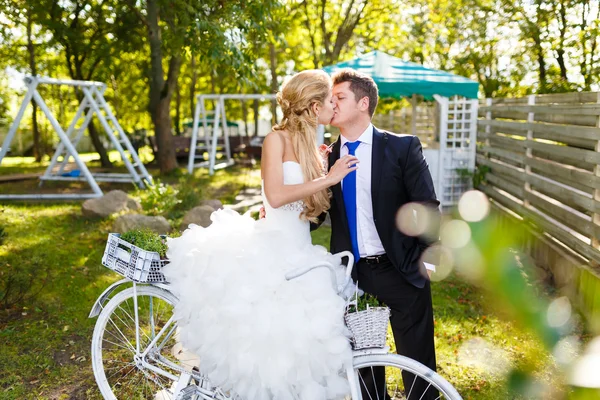Pretty young newlyweds with bike — Stock Photo, Image