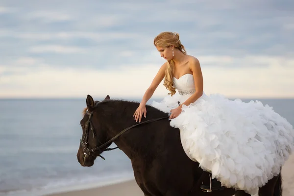 Novia en un caballo junto al mar —  Fotos de Stock