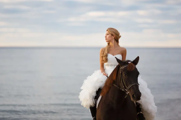 Brud på en häst vid havet — Stockfoto