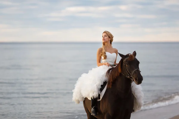 Panna młoda na koniu przez morze — Zdjęcie stockowe
