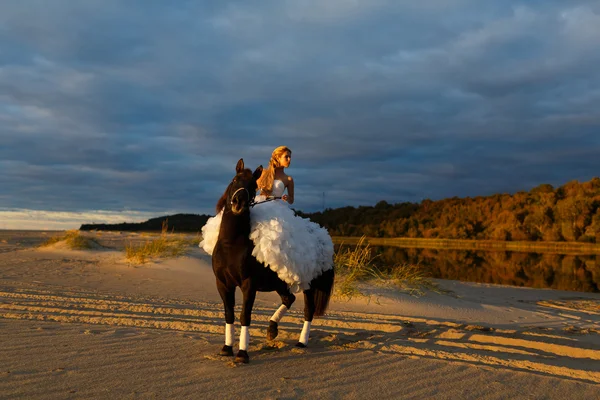 Braut auf einem Pferd bei Sonnenuntergang am Meer — Stockfoto