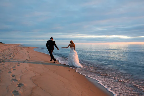 Un couple amoureux marchant au bord de la mer — Photo