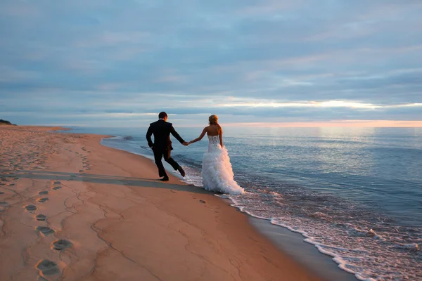 Un couple amoureux marchant au bord de la mer — Photo