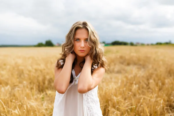 Bir buğday alanında genç güzel kız — Stok fotoğraf