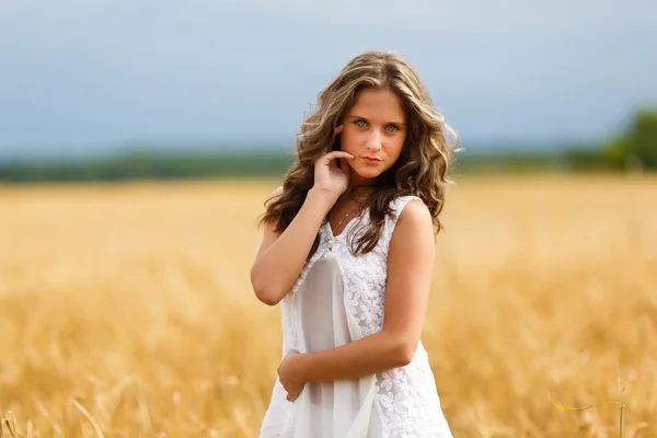 Ung vacker flicka i ett vete fält — Stockfoto