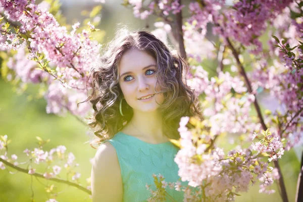 Beautiful young girl in flowers — Stock Photo, Image