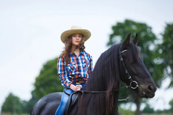 Hermosa joven montando un caballo en el campo —  Fotos de Stock