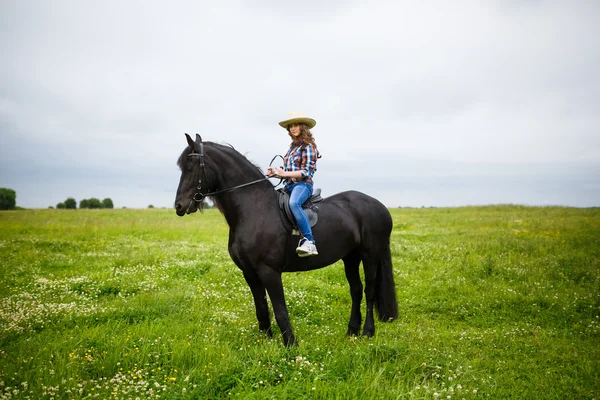 Menina bonita montando um cavalo no campo — Fotografia de Stock