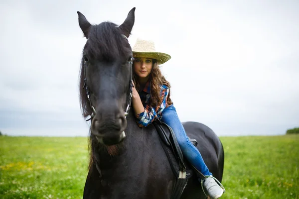 Beautiful young girl riding a horse in countryside — Stock Photo, Image