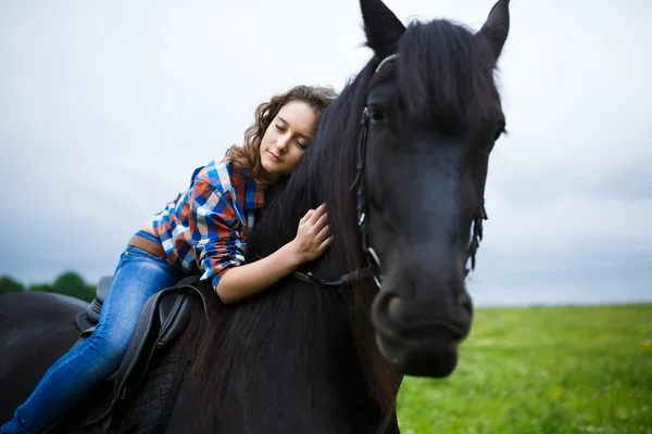 Menina bonita montando um cavalo no campo — Fotografia de Stock