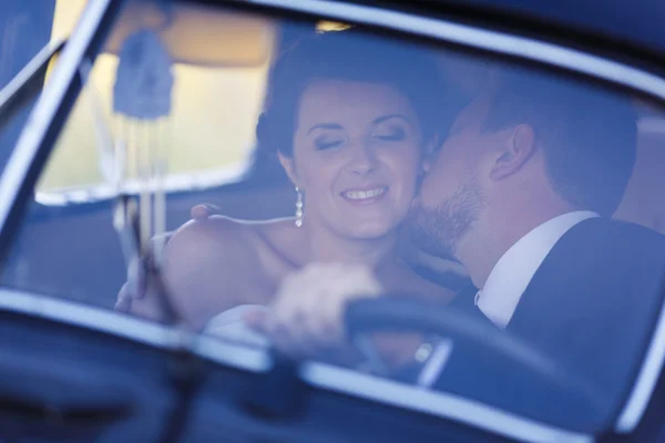Ein Hochzeitspaar im alten Auto — Stockfoto
