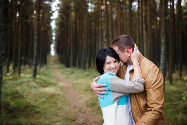 Lyckliga par i en tallskog — Stockfoto