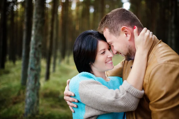 Happy couple in a pine forest — Stock Photo, Image