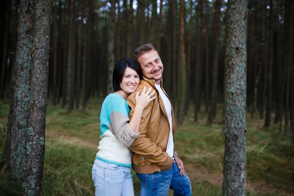 Pareja feliz en un bosque de pinos — Foto de Stock