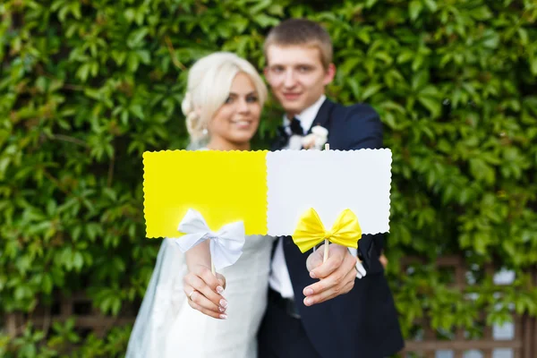 Novia y novio sosteniendo la placa en sus manos —  Fotos de Stock