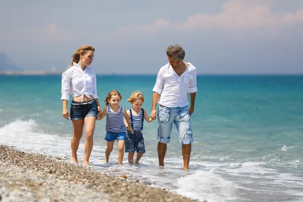 Familie med to børn på stranden - Stock-foto